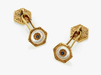 A pair of cufflinks decorated with mother-of-pearl and small sapphires