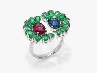 A ring with a red and blue tourmaline and emeralds