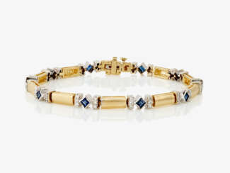 A fancy link bracelet decorated with blue sapphires and brilliant cut diamonds