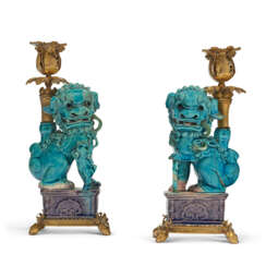 A PAIR OF ORMOLU-MOUNTED CHINESE TURQUOISE AND AUBERGINE BISCUIT-GLAZED PORCELAIN FIGURAL CANDLESTICKS