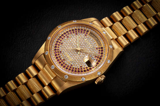 ROLEX, DAY-DATE REF. 18308, A GOLD AND DIAMOND-SET WRISTWATCH WITH PAVED DIAMOND AND RUBY DIAL - Foto 1