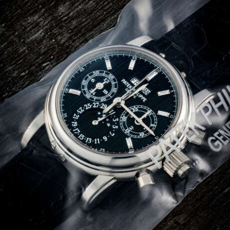 PATEK PHILIPPE. AN EXTREMELY RARE PLATINUM SPLIT SECONDS CHRONOGRAPH PERPETUAL CALENDAR WRISTWATCH WITH MOON PHASES, 24 HOUR, LEAP YEAR INDICATION AND BLACK DIAL WITH BAGUETTE-CUT DIAMONDS, SINGLE SEALED - Foto 1
