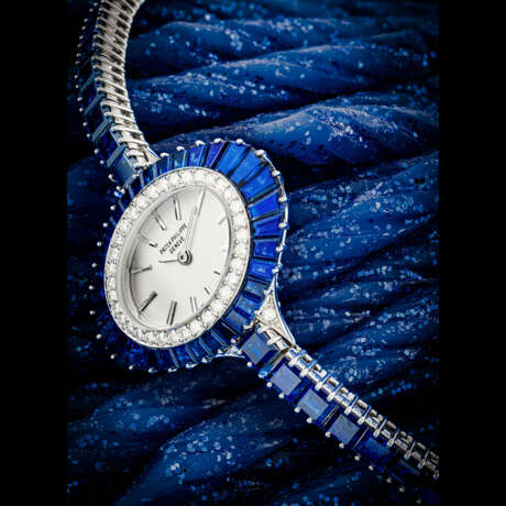 PATEK PHILIPPE. A LADY’S POSSIBLY UNIQUE AND ELEGANT 18K WHITE GOLD, DIAMOND AND SAPPHIRE-SET BRACELET WATCH - фото 1