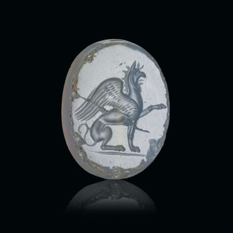 A GRECO-PERSIAN PALE BLUE CHALCEDONY SCARABOID OF A SEATED GRIFFIN - фото 1