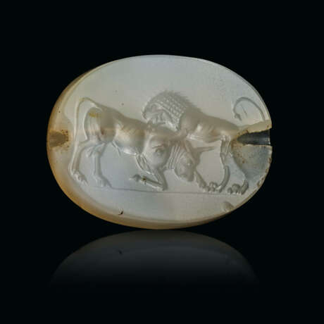 A GRECO-PERSIAN BLUE CHALCEDONY SCARABOID WITH A LION ATTACKING A BULL - фото 1