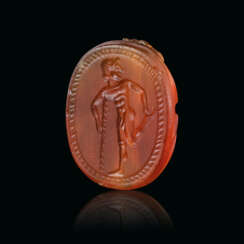 A GREEK CARNELIAN SCARAB WITH A YOUTH LEANING ON A STAFF