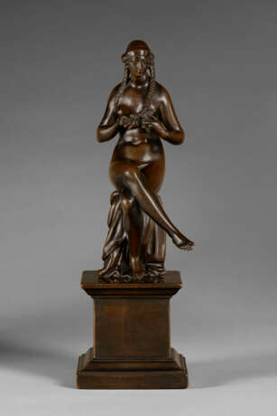 A BRONZE FIGURE OF A SEATED NUDE WOMAN BRAIDING HER HAIR - photo 1