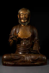 A RARE LACQUERED AND PARCEL GILT WOOD FIGURE OF A SEATED ASCETIC