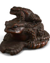 A CARVED WOOD SCULPTURE OF A BABY AND LARGE TOAD ON STRAW SANDAL