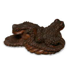 A CARVED WOOD SCULPTURE OF A PAIR OF TOADS ON STRAW SANDAL