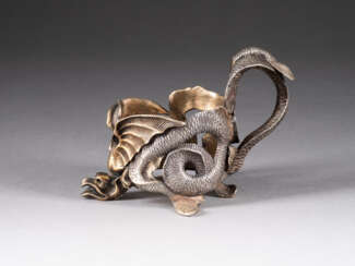 A MASSIVE SILVER TEAGLASS HOLDER IN THE FORM OF A DRAGON