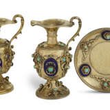 TWO SIMILAR CONTINENTAL ENAMEL AND SILVER-GILT GEM-MOUNTED EWERS AND A STAND - Foto 1