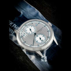 PATEK PHILIPPE. AN 18K WHITE GOLD AUTOMATIC ANNUAL CALENDAR WRISTWATCH WITH REGULATOR-STYLE DIAL, SINGLE SEALED