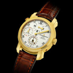 VACHERON CONSTANTIN. AN 18K GOLD AUTOMATIC DUAL TIME WRISTWATCH WITH DATE AND REGULATOR-STYLE DIAL