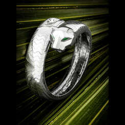 CARTIER. AN ATTRACTIVE 18K WHITE GOLD, EMERALD AND ONYX-SET BANGLE WATCH