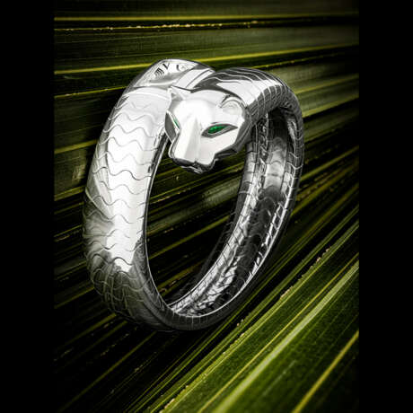 CARTIER. AN ATTRACTIVE 18K WHITE GOLD, EMERALD AND ONYX-SET BANGLE WATCH - фото 1