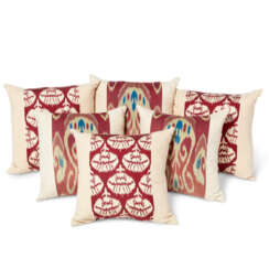 A GROUP OF SIX IKAT SILK AND CREAM LINEN SQUARE CUSHIONS