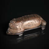 Dreibeinige Kröte aus mittelbraunem Stein auf einem Holzstand - фото 1
