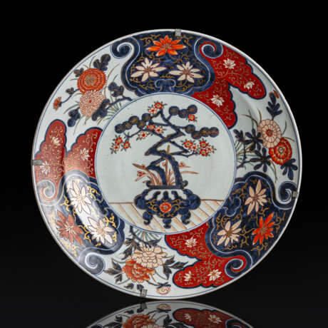 Rundplatte aus Porzellan mit Dekor einer Pflanzschale mit einer kleinen Kiefer und blühenden Pflaumenästen in den Farben der Imari-Palette - photo 1