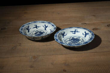 Zwei blütenförmige Teller aus Porzellan mit unterglasurblauem Dekor mythischer Kreaturen und Metallmontierung