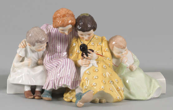 Vier Kinder beim Betrachten einer Puppe - photo 1