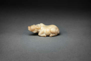 A WELL-CARVED BEIGE AND BROWN JADE FIGURE OF A RECUMBENT WATER BUFFALO