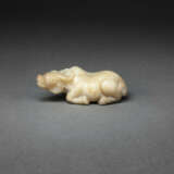 A WELL-CARVED BEIGE AND BROWN JADE FIGURE OF A RECUMBENT WATER BUFFALO - фото 1