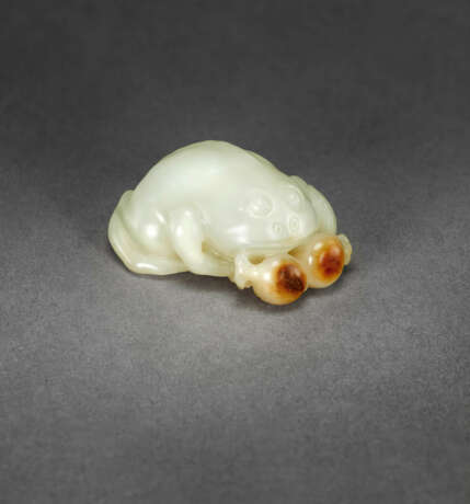 A WHITE AND RUSSET JADE FIGURE OF A THREE-LEGGED TOAD WITH POMEGRANATES - Foto 1