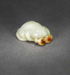 A WHITE AND RUSSET JADE FIGURE OF A THREE-LEGGED TOAD WITH POMEGRANATES