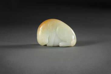 A SUPERB WHITE AND RUSSET JADE FIGURE OF A MYTHICAL BEAST