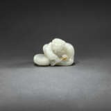 A FINELY CARVED WHITE JADE FIGURE OF A BOY WITH A DRUM - photo 1