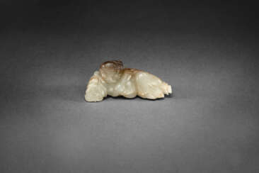 A PALE GREENISH-WHITE AND RUSSET JADE CARVING OF A BOY AND LOTUS