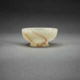 A RARE BEIGE AND RUSSET JADE FOOTED CUP - photo 1
