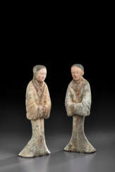A PAIR OF PAINTED POTTERY FIGURES OF ATTENDANTS