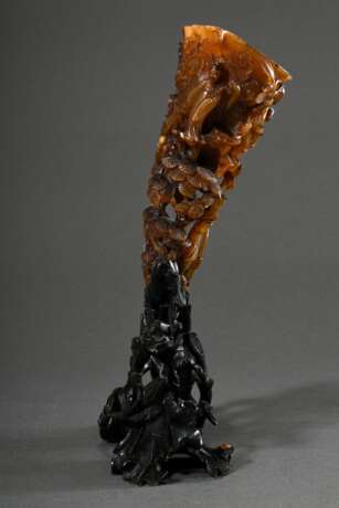 Beschnitzter Büffelhorn Libationsbecher "Sechs daoistische Figuren in Rankenwerk zwischen Kiefern und Prunus" auf geschnitztem Blackwood Stand, China, Qing Dynastie, 29,5x16,5x9,5cm, kleine Defekte - Foto 4