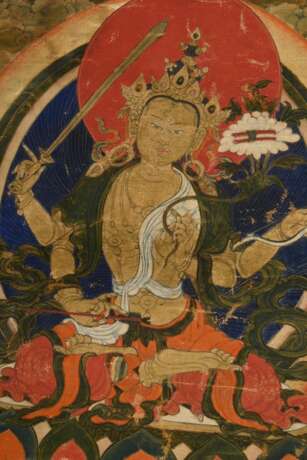 Tibetischer Thangka „Vierarmiger Caturbhuja Manjushri“ mit Schwert, Pfeil und Bogen, Lotosblüte und Buch, im Lotossitz, darunter zwei Lamas, 33x23,5cm (65x46cm mit Stoffrahmung), Altersspuren - photo 3