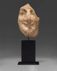AN ETRUSCAN PAINTED TERRACOTTA FEMALE HEAD FROM AN ANTEFIX
