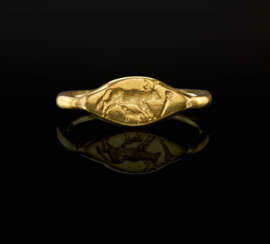 A GREEK GOLD FINGER RING WITH A COW SUCKLING A CALF