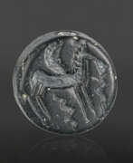 Geometric art (900-700 BC). A GREEK BLACK SERPENTINE DOUBLE-SIDED DISK WITH A CENTAUR AND A WINGED HORSE