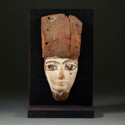 AN EGYPTIAN PAINTED WOOD FACE FROM A COFFIN