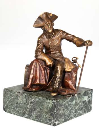 Bronze-Figur "Alter Fritz", mit Dreispitz und Degen auf einem Baumstamm sitzend, die linke Hand auf einen Stab gestützt, braun patiniert und farbig gefaßt, rückseitig bezeichnet "Titze", H. 13 cm, auf grünem Marmorsockel, Ges.… - фото 1