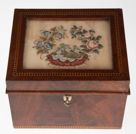 Biedermeier-Kästchen, Mahagoni, im Deckel zarte florale Petit Point-Stickerei mit Störchen unter Glas, umlaufende Intarsienbänder, innere Bleiauskleidung mit Gebrauchspuren, seitl, kl. Furnierfehlstelle, mit Schlüssel, 14x19,5x16,5 cm - фото 1