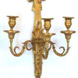 Wandleuchter, 3-armig, 19. Jh., Bronze feuervergoldet, in Form einer Fackel mit 3 Volutenarmen mit eingepaßten Tüllen, Leuchter mit Schleifenbekrönung, nachträgliche Bohrungen, H. 48 cm, B. 33 cm - Foto 1