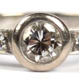 Brillant-Ring, 750er WG, mit Solitär von 0,5 ct. in Zargenfassung, vsi, flankiert von 5 kl. Brillanten, ges. 5,2 g, RG 63 - фото 1
