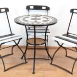 Gartentisch und 3 Klappstühle, schwarz/weiß neu gefaßt, Tisch auf Metallgestell mit 3 Füßen und Zwischenablage, Platte mit eingelegtem Steinmosaik, Gebrauchspuren, H. 71 cm, Dm. 60 cm - photo 1