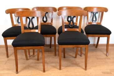 Biedermeier-Tisch mit 6 Stühlen, Kirschholz, um ca. 1820, Tisch mit sechseckiger Mittelsäule, mit schwarz gefärbtem Birnbaumholz, Tischplatte in massiv Buche erneuert, Tischplatte mit Riß, Dm. 117 cm, H. 77,5 cm, bei den Stühlen ist der Sitz in …