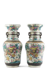 Pair of polychrome porcelain vases decorated with battle scenes in a mountain landscape, bearing the apocryphal mark
