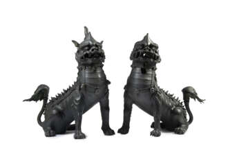 Pair of seated Buddhist lions finely crafted in cast iron, face with open jaws and raised tail