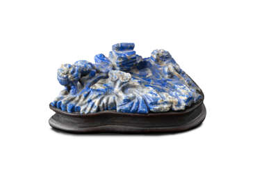 A lapis lazuli brush washer, carved as a rocky lake with buddhist lions and ruyi motifs, on wood base