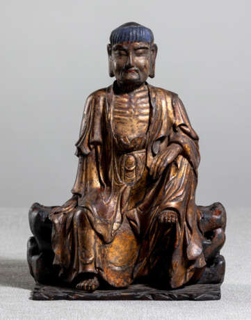 Feine Holzfigur des Buddha Shakyamuni auf einem Felsen sitzend mit Lackvergoldung - photo 1